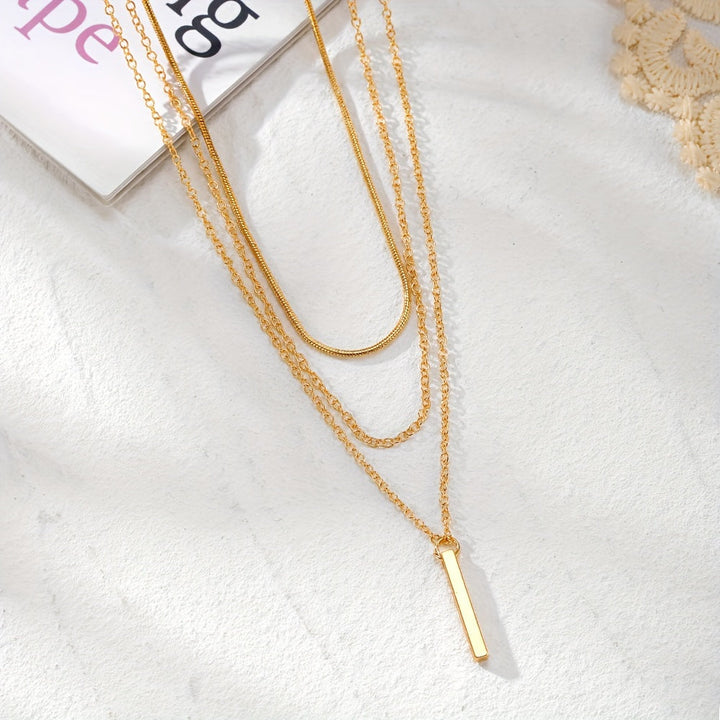 Dames model draagt elegante gouden Y-ketting met fijne kralen, perfect voor een feestelijk cadeau.