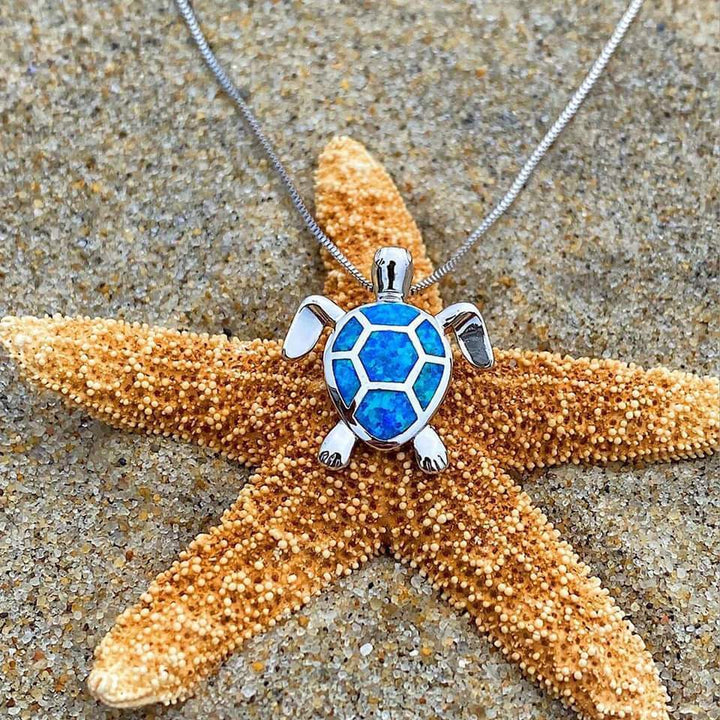 Trendy zilveren zeeschildpad ketting en oorbellen set, met glanzend opaal en maritiem design, ideaal cadeau voor dames.