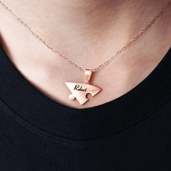 Zilverkleurige familie puzzelketting met gegraveerde namen, symbool van liefde.