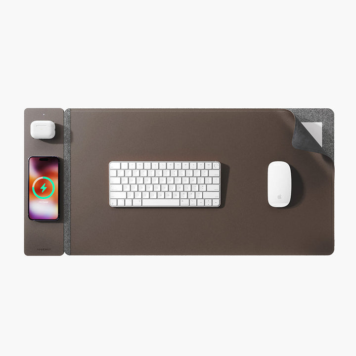 Bovenaanzicht van de ChargePad Flex draadloze bureaumat, een opladende smartphone en een computermuis. Strak design.