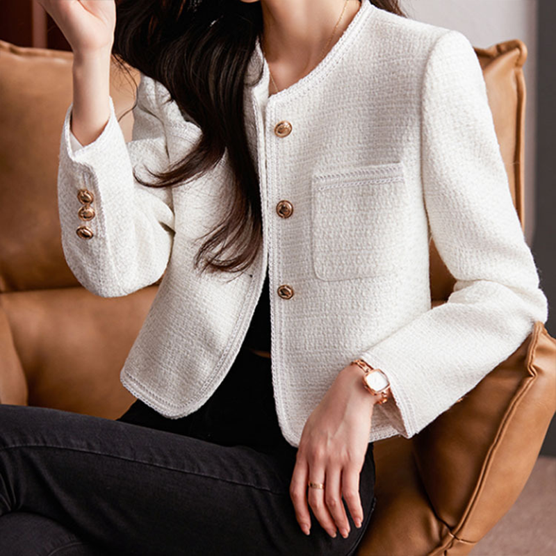 Witte damesblazer, kort model, elegant afgewerkt met gouden details, ideaal voor lente mode.