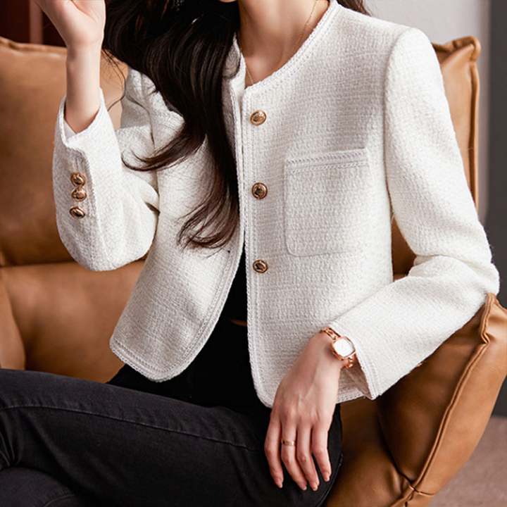 Witte damesblazer, kort model, elegant afgewerkt met gouden details, ideaal voor lente mode.