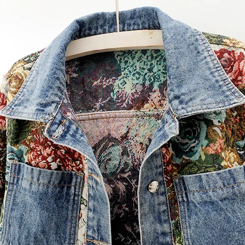 Blauw denim damesjack met kleurrijke, verfijnde bloemenprint voor casual of chique gelegenheden.