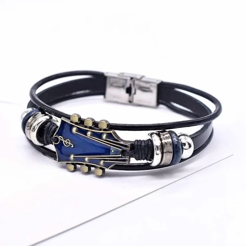 Gedetailleerde foto van de gitaarbedel op de leren armband, benadrukt vakmanschap en stijl.