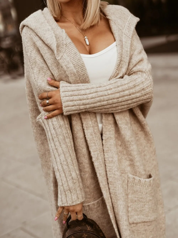 Modern gebreid lang damesvest met capuchon, zacht en heerlijk warm, voor diverse casual outfits.