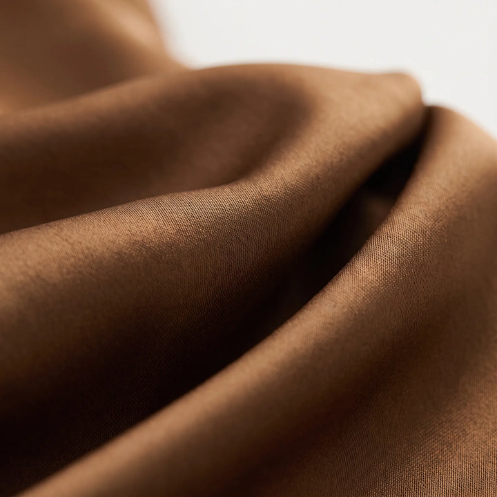 Modieuze bronzen dames midi jurk, asymmetrisch design, perfect als elegante avondjurk of voor speciale gelegenheden.