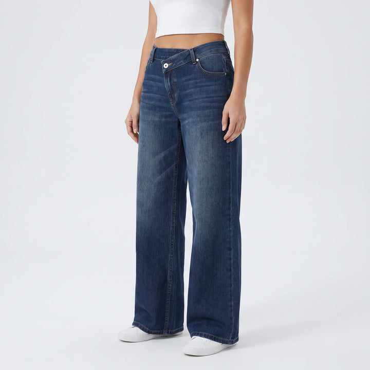 Detail van asymmetrische knoopsluiting op een dames wijde jeans met hoge taille; unieke spijkerbroek.