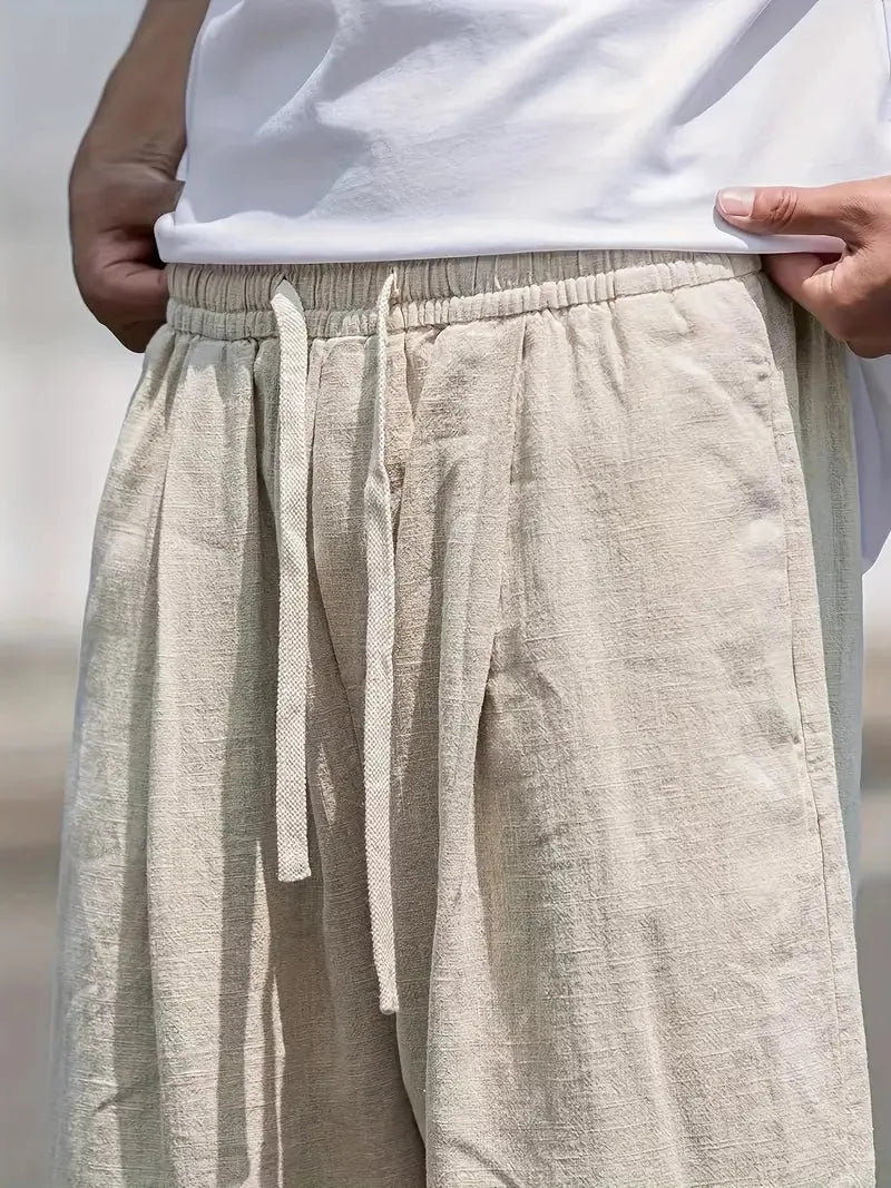 Gedetailleerd beeld van de beige baggy linnen broek, benadrukt de zachte stof en comfortabele elastische taille.