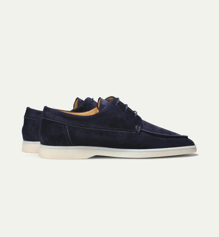 Zijaanzicht van klassieke herenloafers met subtiele details, benadrukt elegantie en comfort.