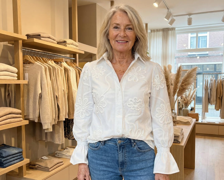 Witte damesblouse met verfijnd borduurwerk en elegante rufflemouwen; een veelzijdige top voor elk seizoen.