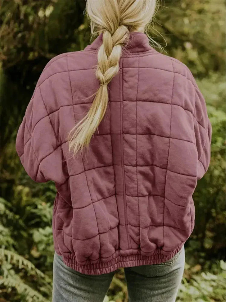 Close-up van het oversized dames bomberjack gedragen door een model, met opstaande kraag.