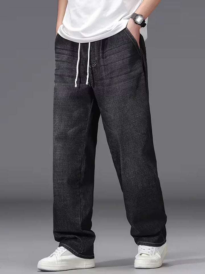 Vooraanzicht van casual heren spijkerbroek met losse pasvorm, elastische taille en ruime zakken.