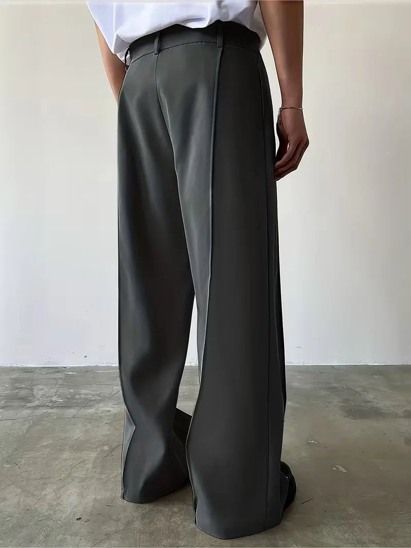 Klassieke donkergrijze pantalon, wijde pijp en geplooid; veelzijdige herenmode.