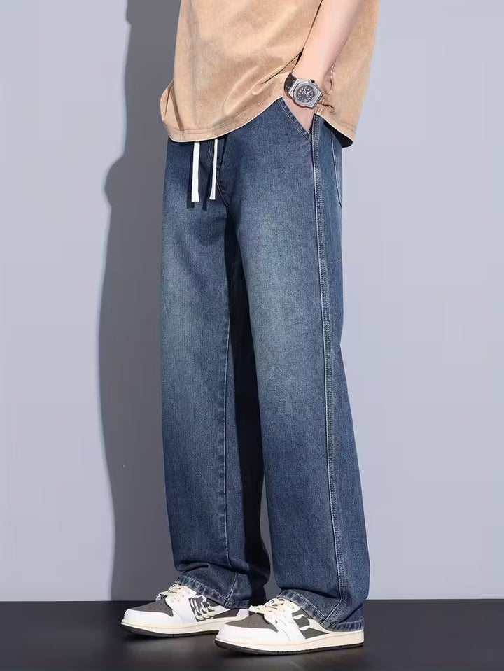 Model draagt comfortabele straight fit jeans, losse pasvorm ideaal voor casual herenmode.