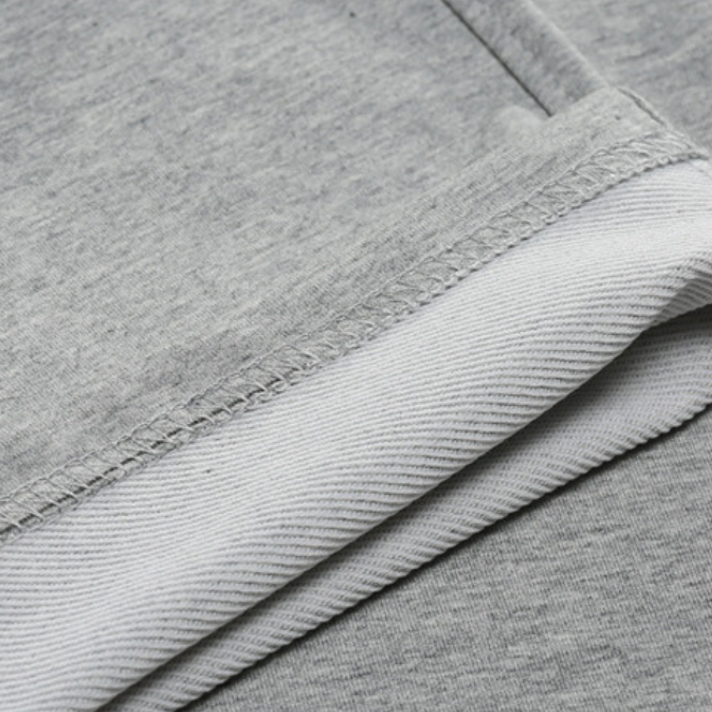 Close-up van de textuur van de VHM heren joggingbroek, zacht en duurzaam polyester voor comfort.