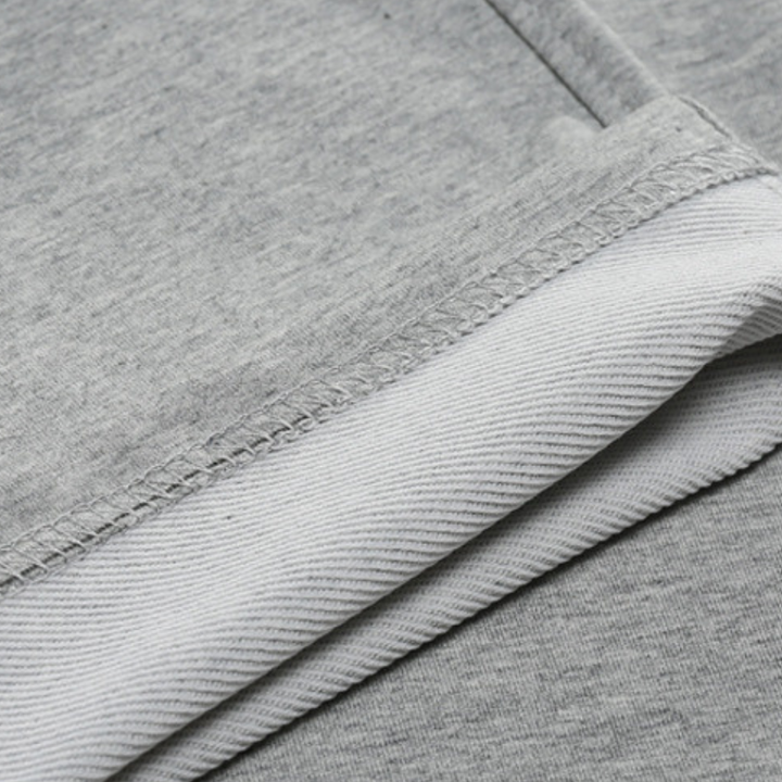 Close-up van de textuur van de VHM heren joggingbroek, zacht en duurzaam polyester voor comfort.