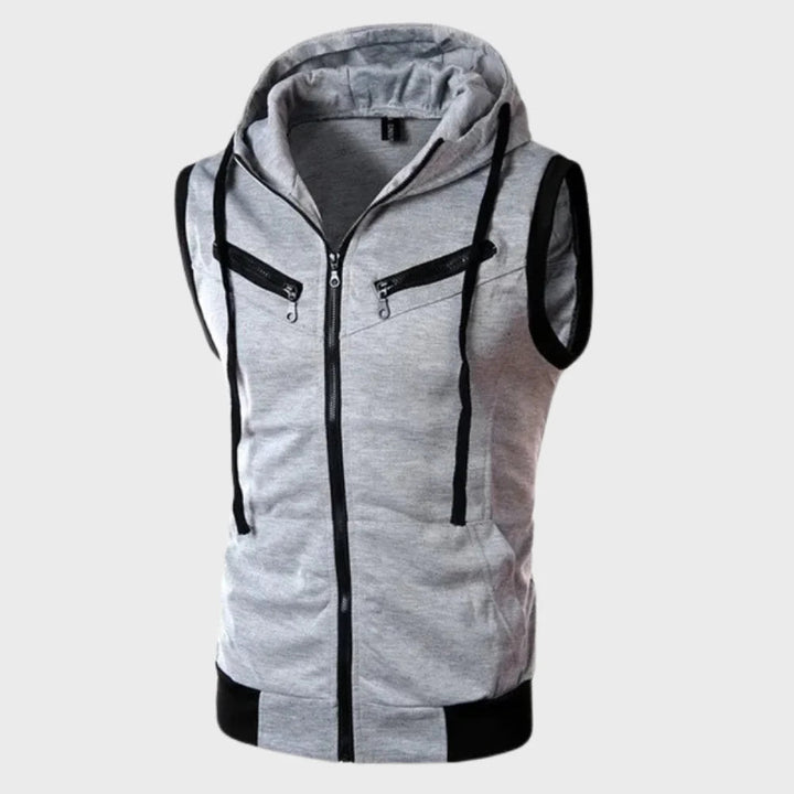 Man draagt trendy heren mouwloos vest met capuchon, perfect voor een relaxte zomerse of lente casual look.
