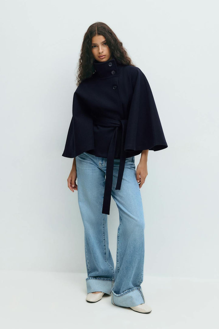 Dames bovenkleding: stijlvolle capejas met hoge kraag, tailleceintuur en een chique uitstraling.