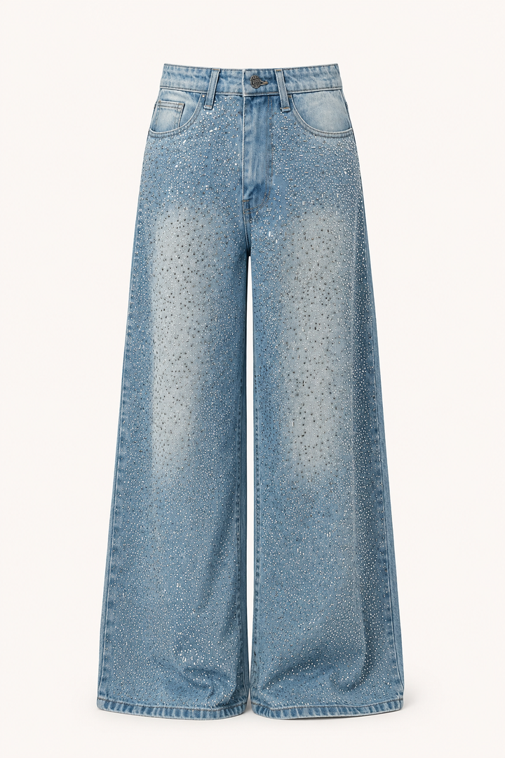 Detailopname van sprankelende strass decoratie op de blauwe damesjeans met wijde pijpen. Voegt glamour toe aan de broek.