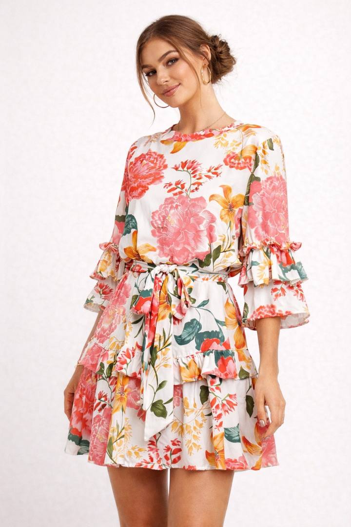 Vrouwelijke zomerjurk met bloemenprint, ruches en strikdetails. Ideaal als elegante casual damesjurk.