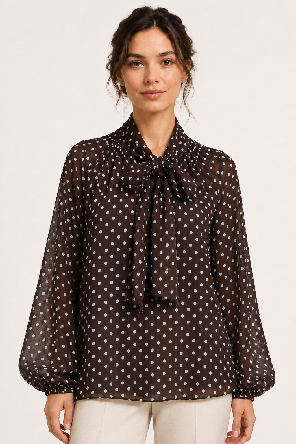Moderne damesblouse met beige stippen, strikdetail en pofmouwen. Geschikt voor een chique kantoorlook of casual.