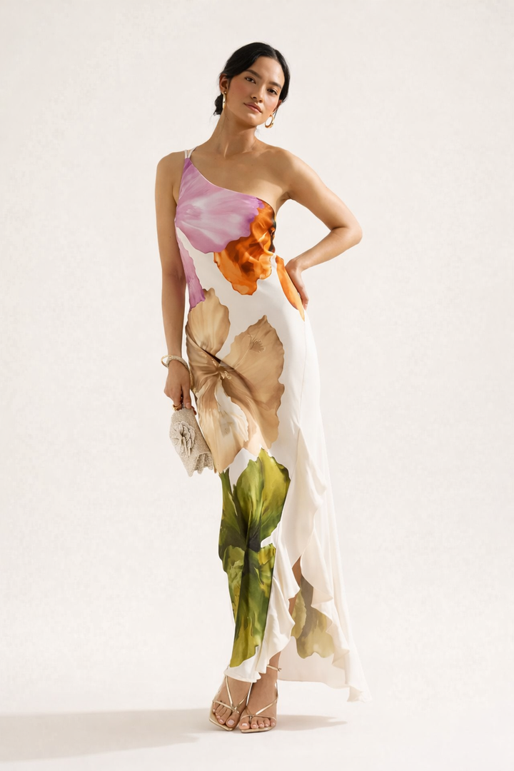 Vrouwelijke lange zomerjurk wit met bloemen, asymmetrisch ontwerp en one-shoulder, perfect voor dames.