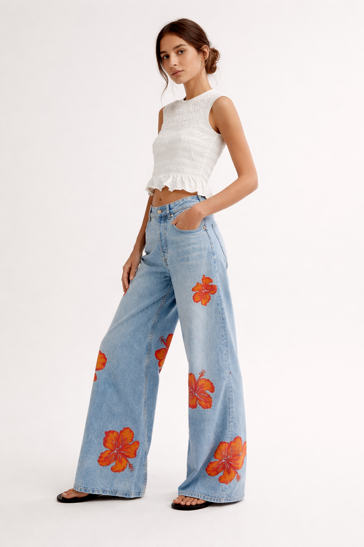 Vrouwelijke damesbroek met wijde pijpen en levendige bloemenprint, ideaal voor een modieuze lente- of zomerlook.