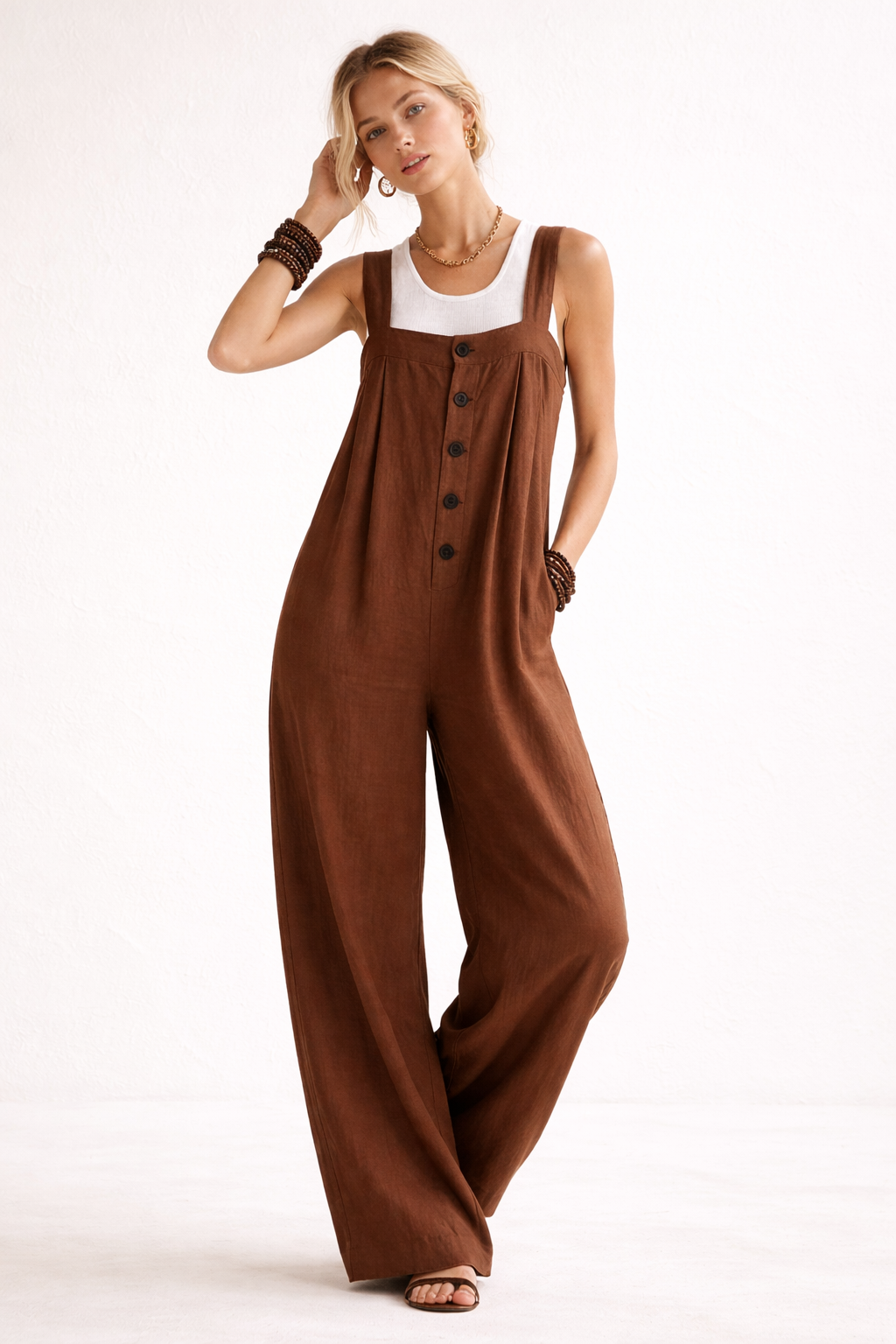 Trendy lange dames jumpsuit, geschikt als lente outfit. Met brede banden en speelse knopen op de voorkant.