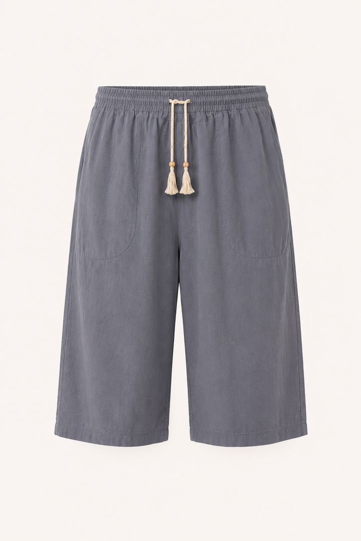 Detail van elastische taille met trekkoord op casual heren zomerbroek. Cropped pijpen voor losse pasvorm.
