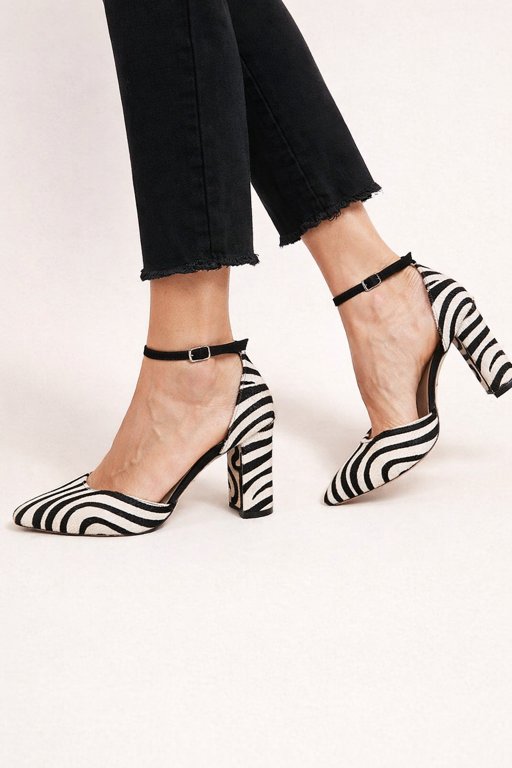 Elegante damesschoenen met zebraprint, hoge hak en stijlvol enkelbandje. Perfect voor feesten en modebewuste vrouwen.