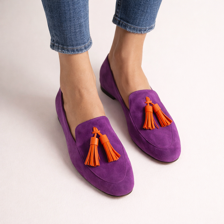 Comfortabele paarse dames instappers met kwastje. Elegante zomerschoenen met platte zool voor een casual look.