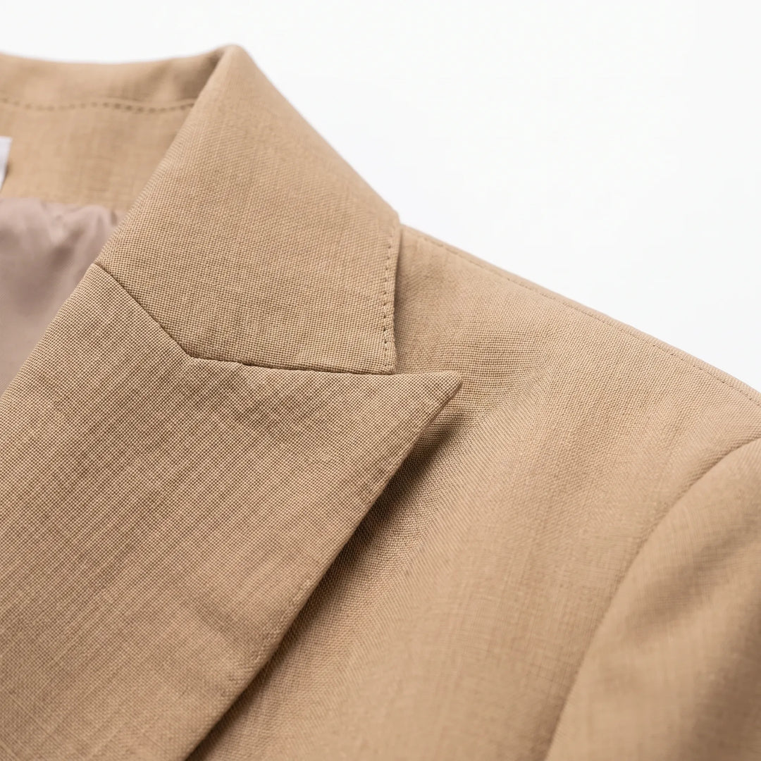 Vrouw draagt chique khaki broekpak met oversized pasvorm, ideaal als comfortabele en zakelijke kantooroutfit.