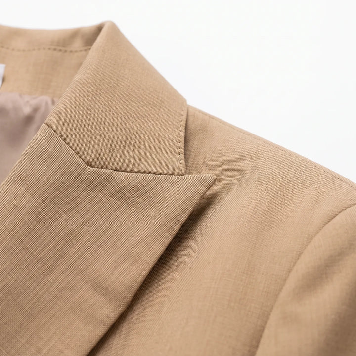 Vrouw draagt chique khaki broekpak met oversized pasvorm, ideaal als comfortabele en zakelijke kantooroutfit.