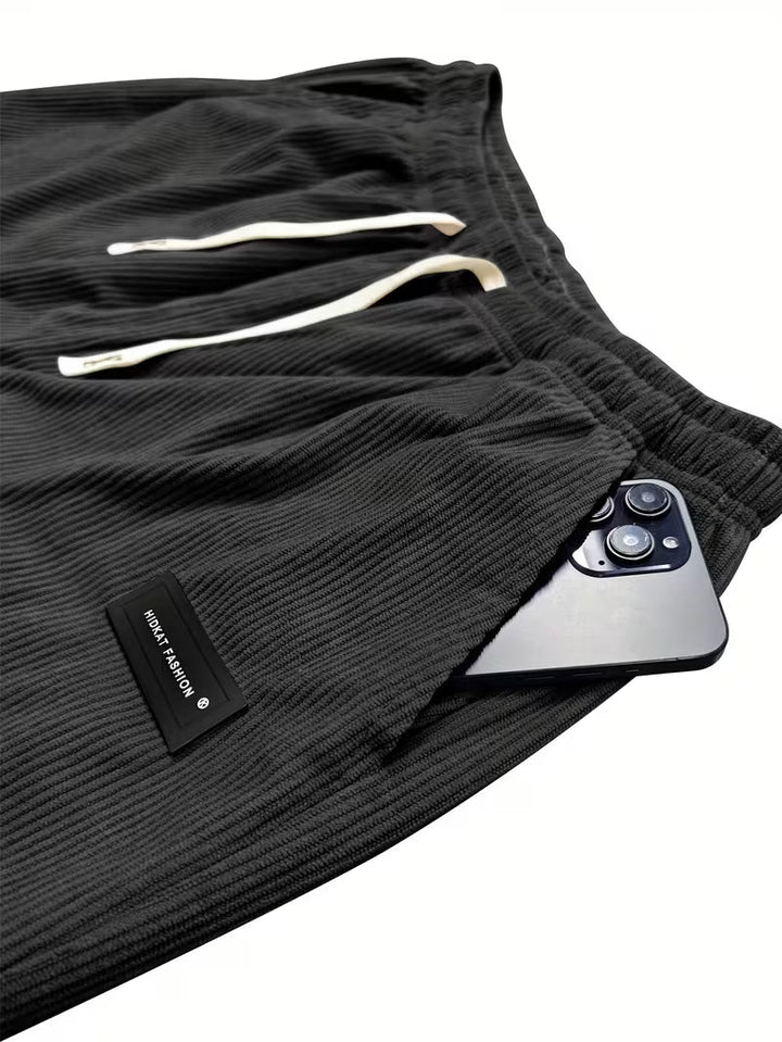 Man draagt comfortabele heren corduroy broek met rechte pijpen en losse pasvorm, perfect voor dagelijks gebruik.