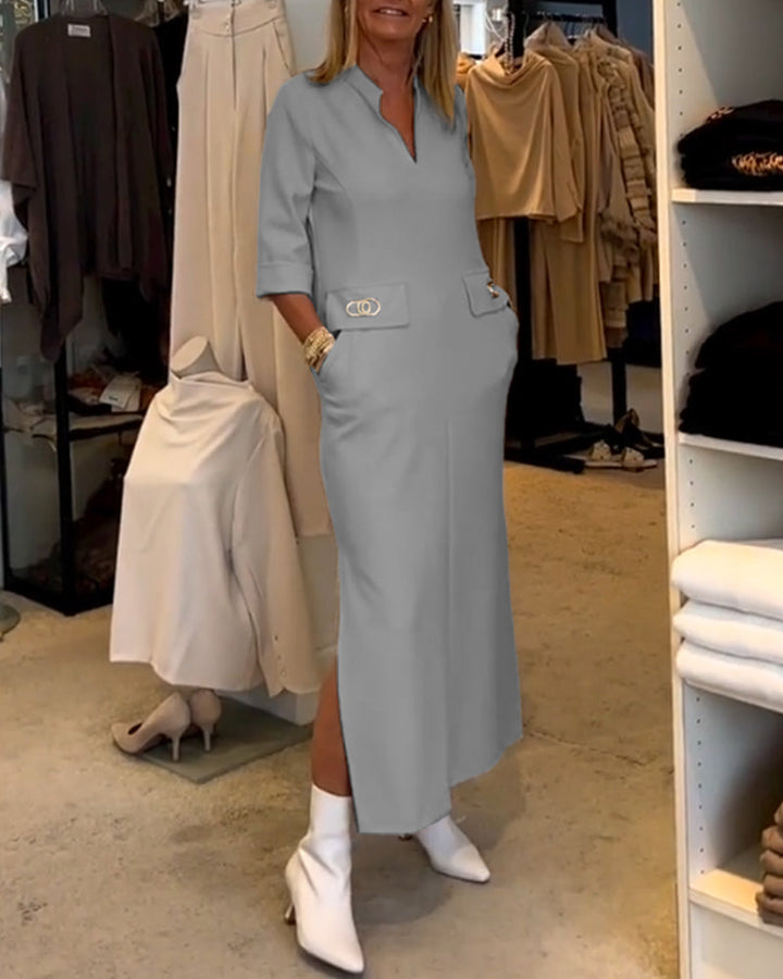 Vrouw die elegant loopt in de comfortabele midi jurk met V-hals, 3/4 mouwen en zakken. Perfecte pasvorm.