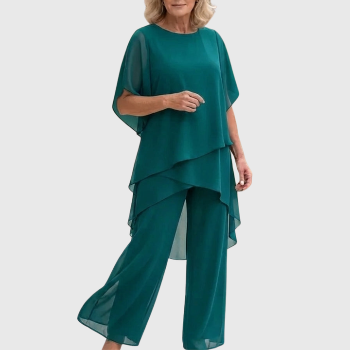 Model draagt comfortabele tweedelige set met asymmetrische top en wijde palazzo broek, ideaal voor de zomer.