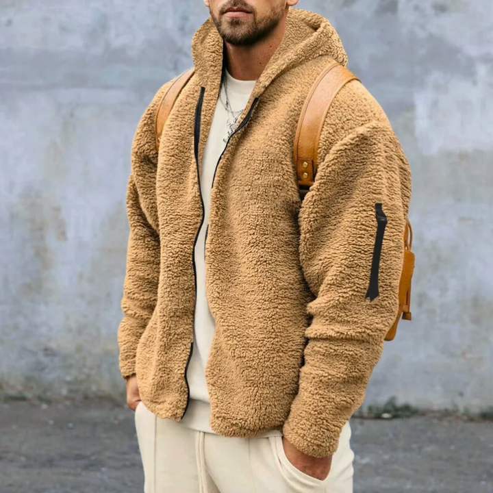 Man draagt warm herenvest met capuchon en rits, casual look, perfect voor koude winterdagen.