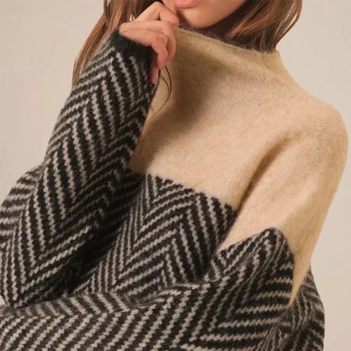 Vrouw draagt comfortabele dames coltrui met visgraatpatroon. Relaxed fit trui, perfect voor een elegante herfstlook.