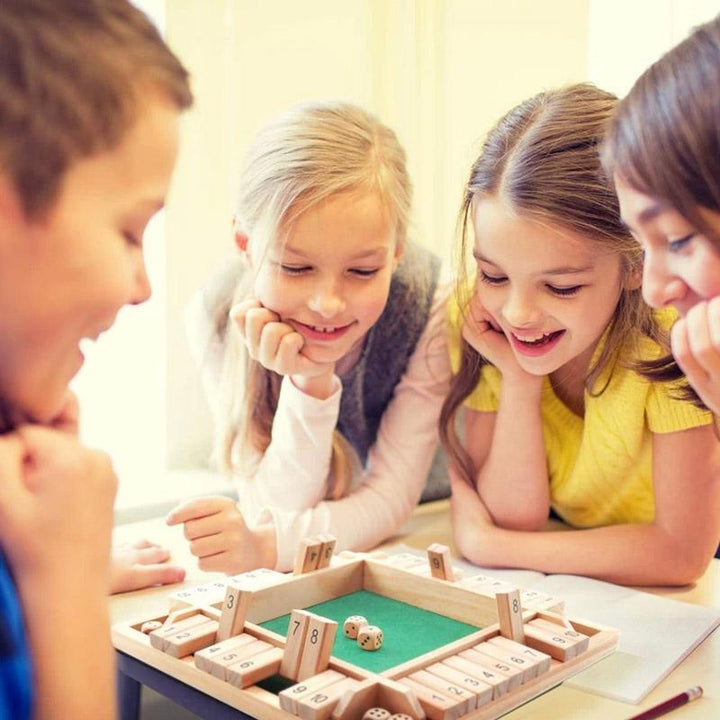 Personen spelen een spannend dobbelspel aan tafel. Dit gezelschapsspel zorgt voor plezier en vermaak voor familie en vrienden.