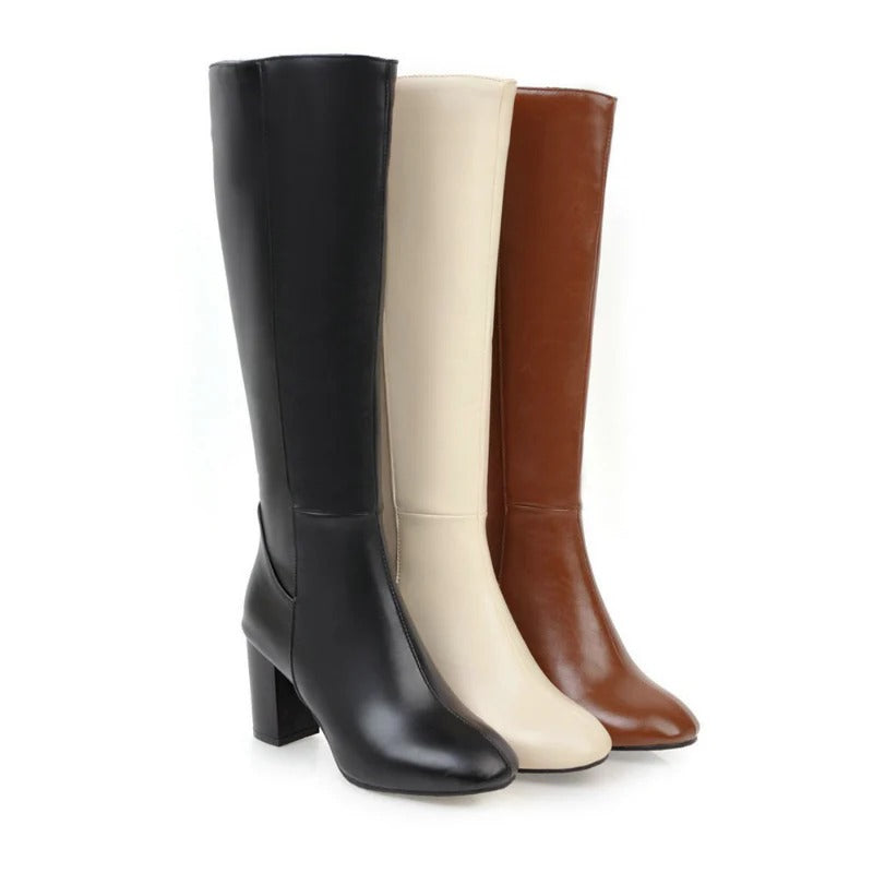 Volledige weergave van beige kniehoge dameslaarzen met een moderne hak en soepele ritssluiting. Modieuze schoenen.
