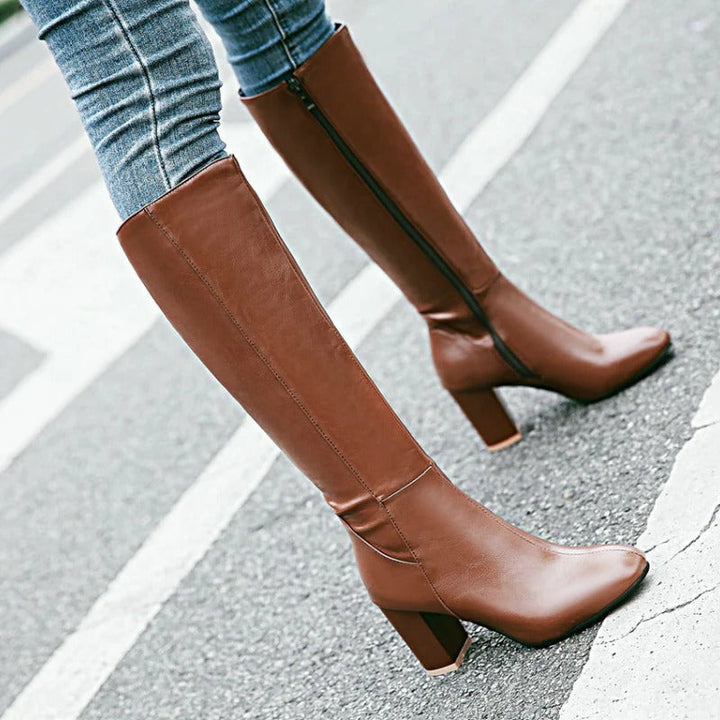 Bruine elegante kniehoge laarzen voor dames met een mooie hak en praktische ritssluiting. Essentiële damesmode.