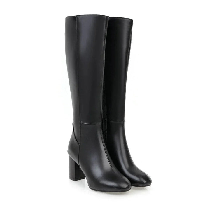 Zwarte kniehoge dameslaarzen met een stabiele blokhak en een functionele ritssluiting. Elegante comfortabele schoenen.