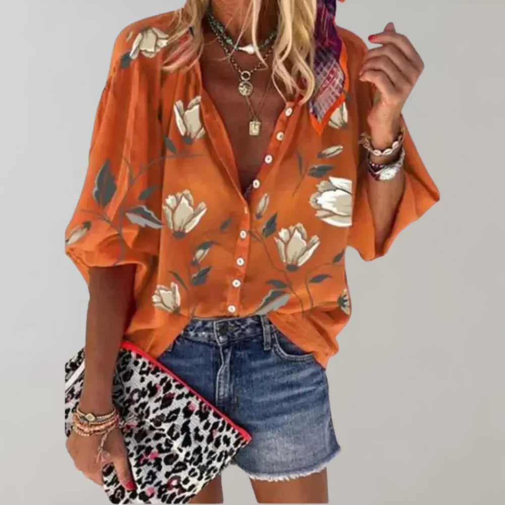Detail van de kleurrijke bloemenprint op deze elegante dames zomerblouse met lange mouwen; frisse stijl.