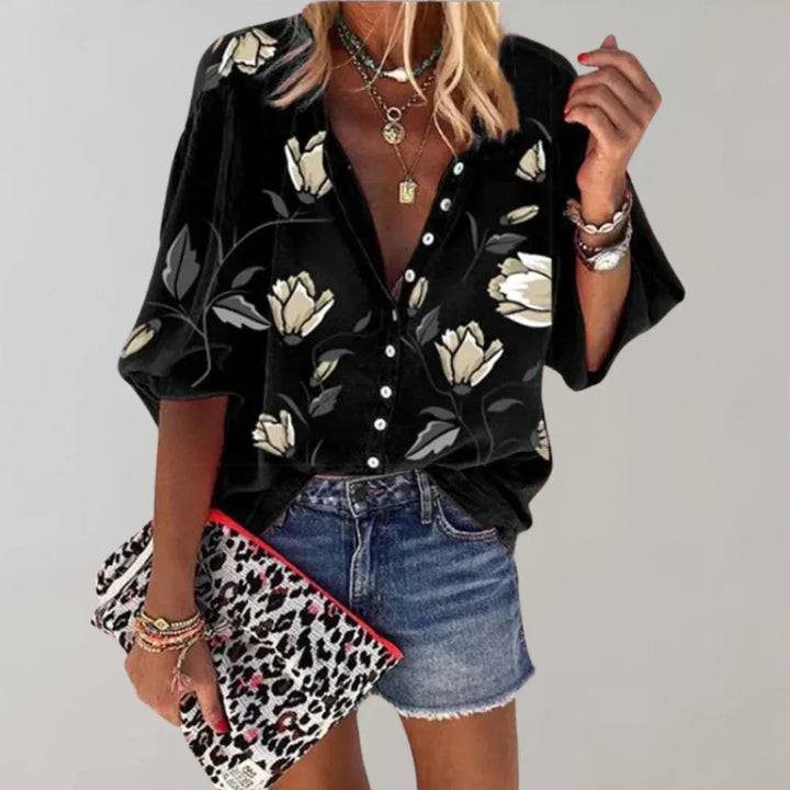 Vrouwelijke zomerbloes met levendige bloemenprint, lange mouwen; ideaal voor casual en feestelijke gelegenheden.