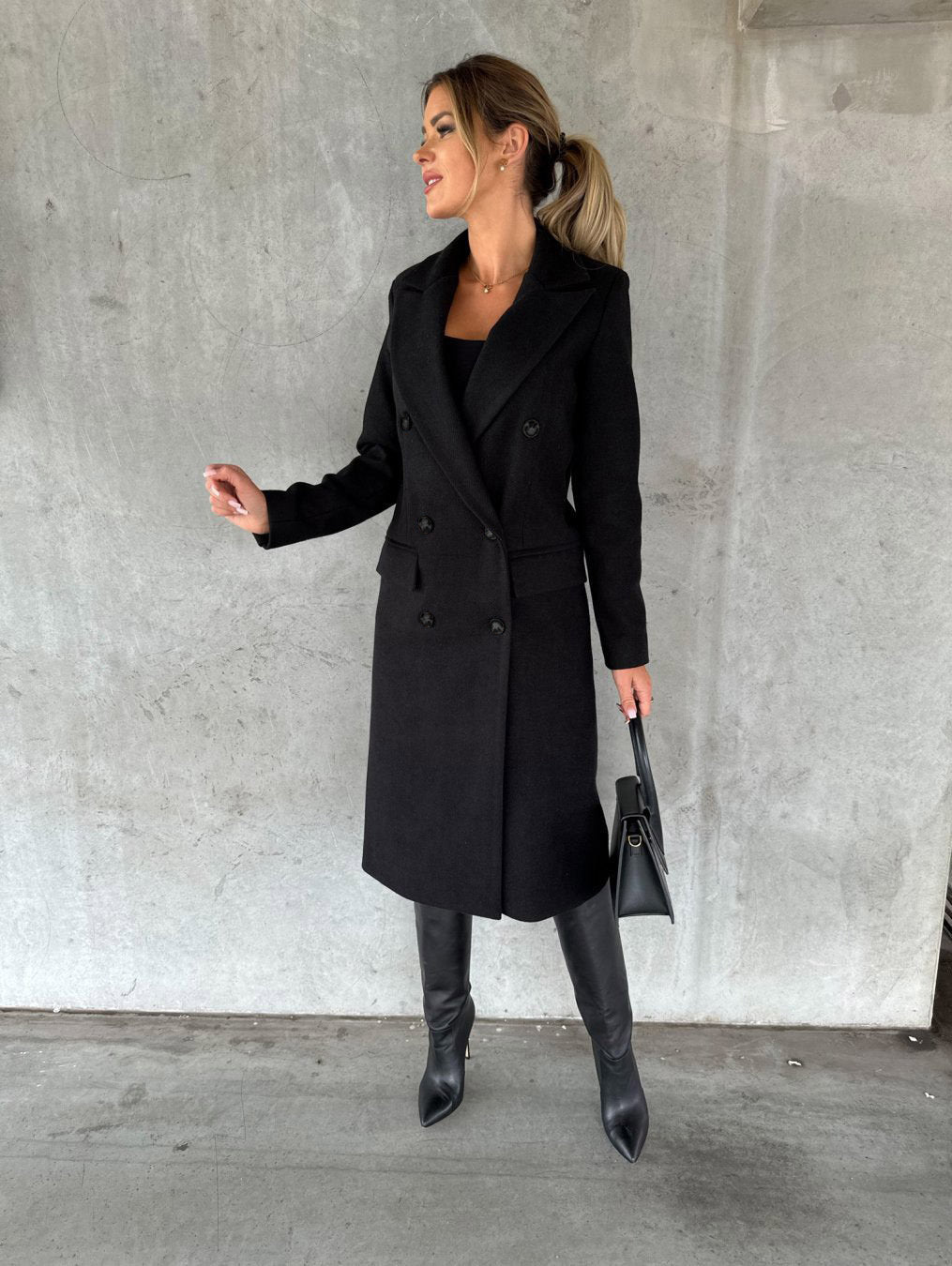 Zwarte elegante damesjas, dubbelrij mantel. Tijdloze lange bovenkleding voor stijlvolle en comfortabele outfits.