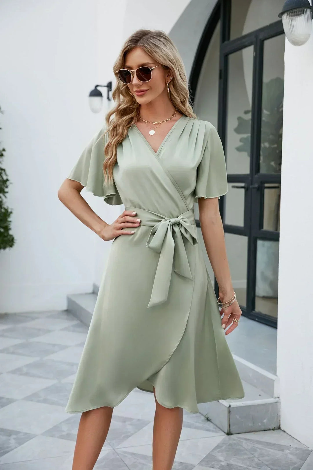 Elegante dames wikkeljurk met strikdetail en V-hals, perfect voor zomerse dagen of feesten.