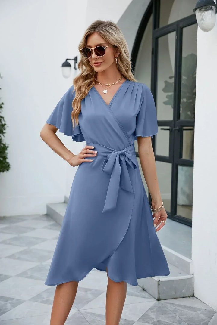 Moderne wikkeljurk voor dames met strikdetail en soepele stof, geschikt als zomer- of feestjurk.