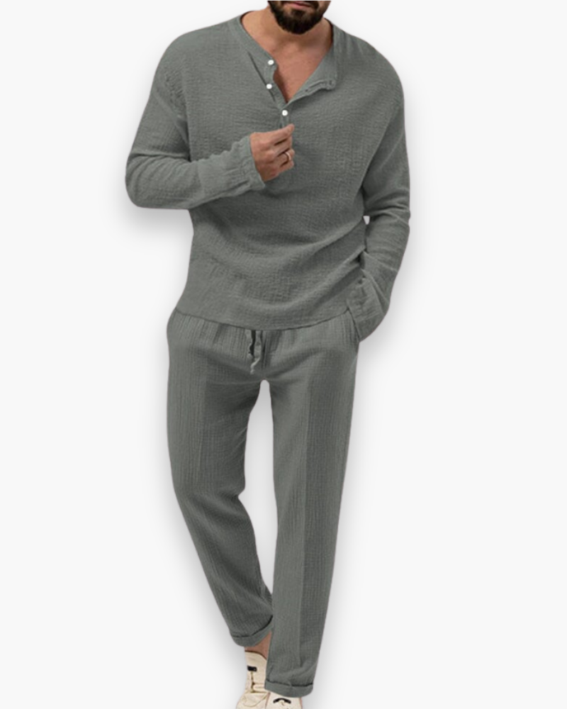 Man toont ademende herenset, top en broek, voor zomercomfort. Een chique, losvallende outfit perfect voor vakantie.