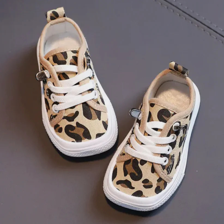 Kind trekt eenvoudig comfortabele barefootsneakers aan, perfect voor speelse avonturen en gezonde ontwikkeling.