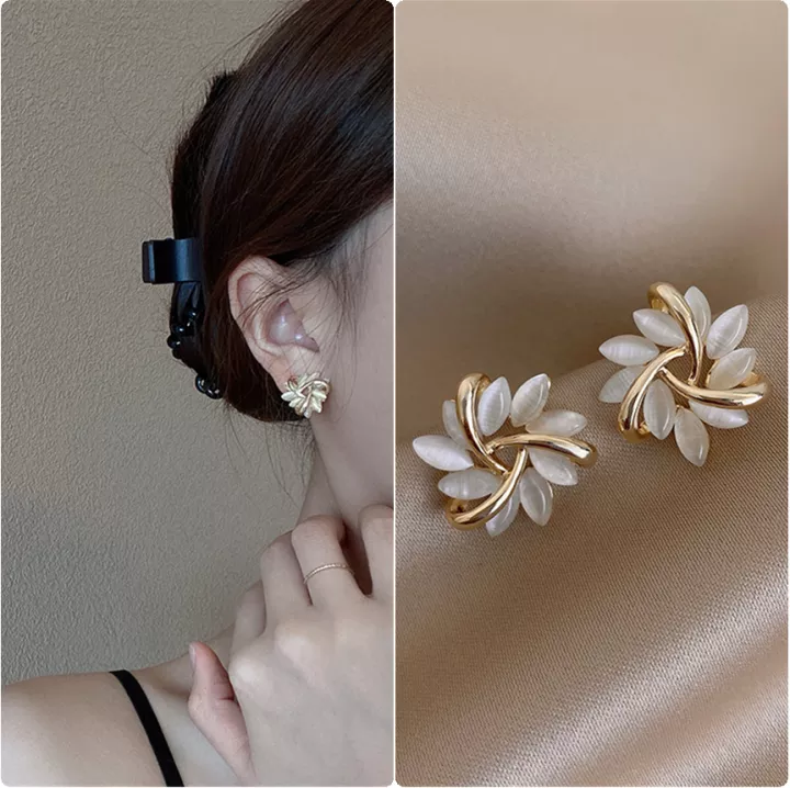 Close-up van elegante dames opaalbloem oorknopjes, verguld. Gedetailleerde bloemknopjes met opaal.